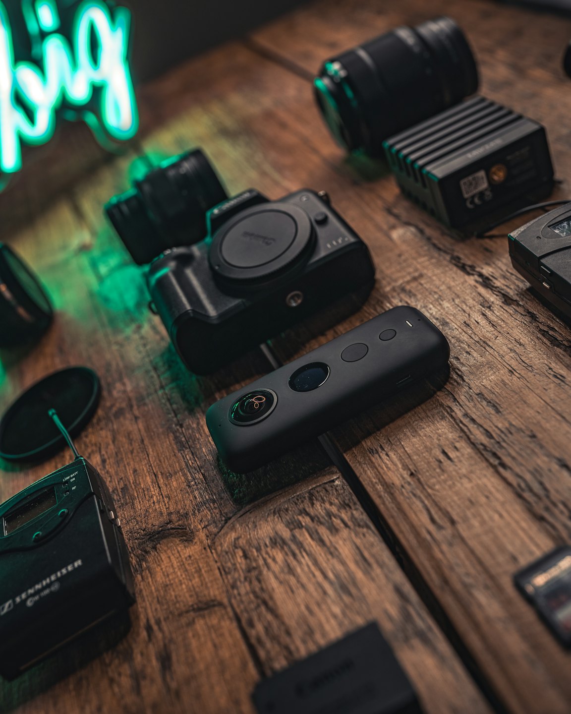 Professional photography and video equipment arranged on a wooden table.