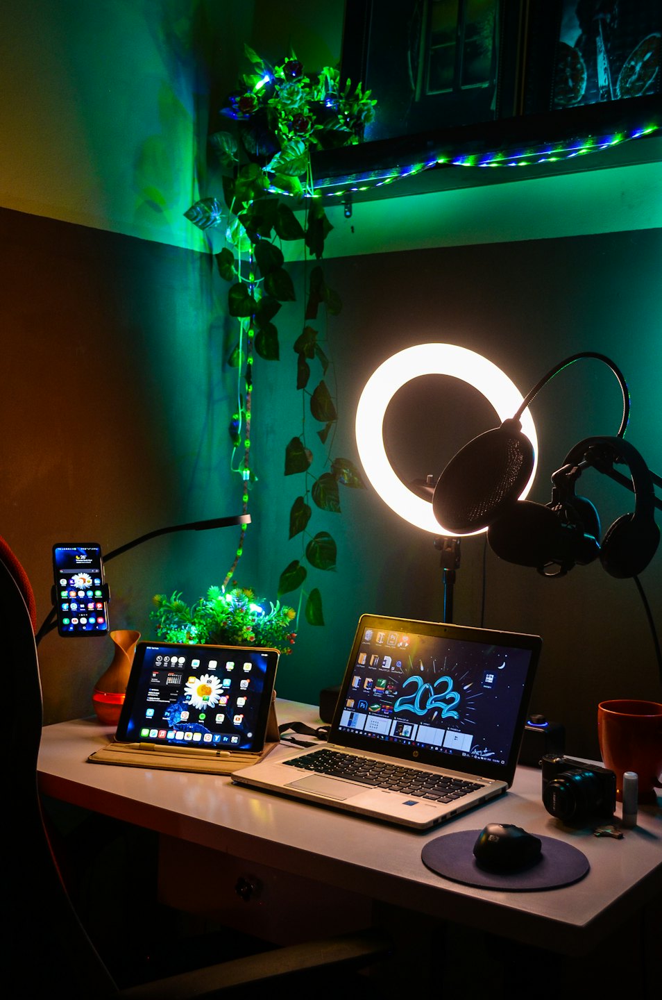 Laptop, tablet, and smartphone on a desk in a creative workspace.
