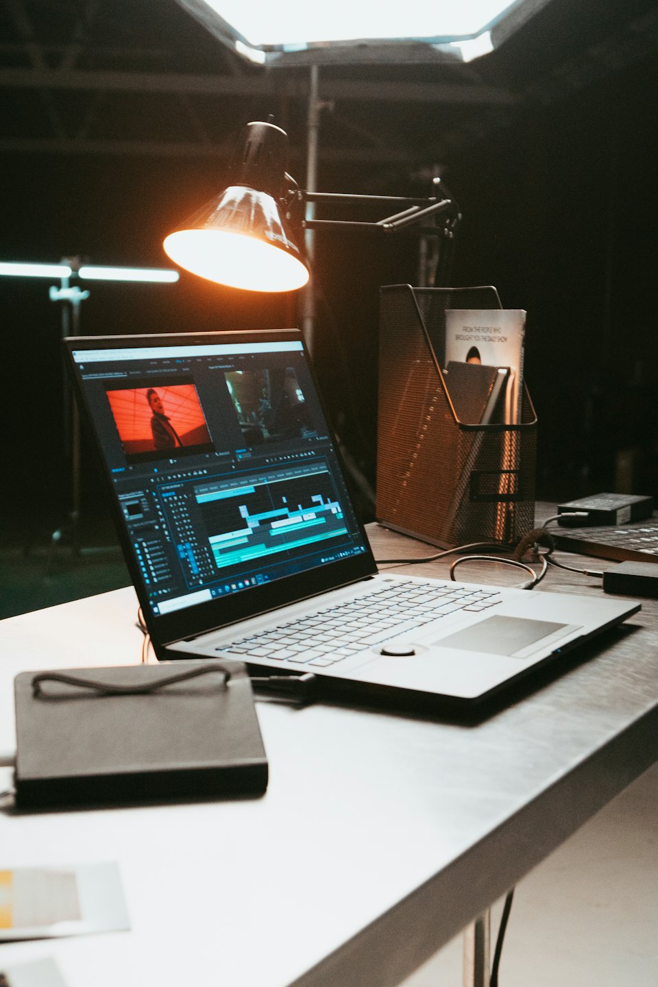 Laptop screen shows video editing software timeline with clips.