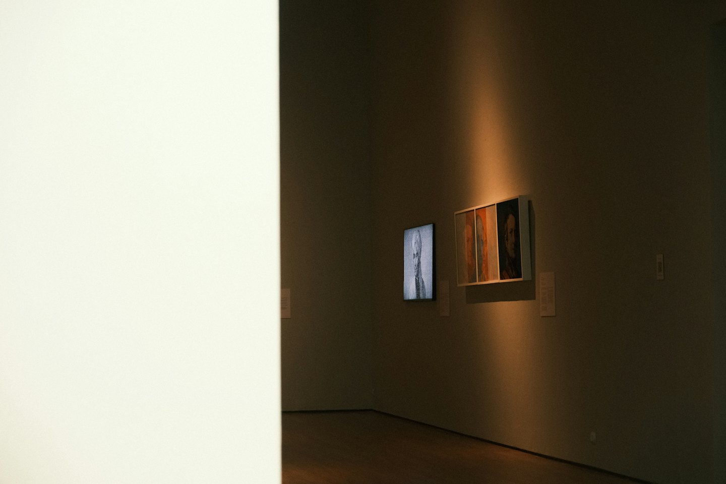 Artworks displayed on a grey gallery wall.